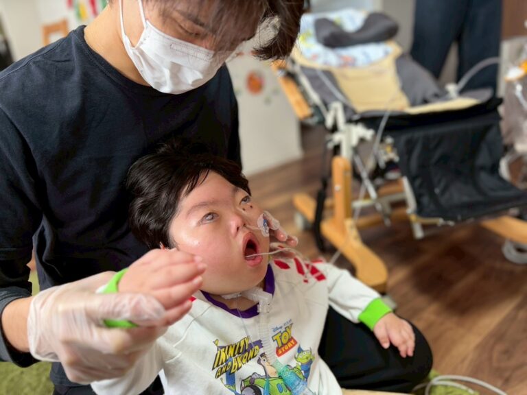 訪問先で、スタッフが医療的ケアを必要とするお子さんに食事の介助をしている