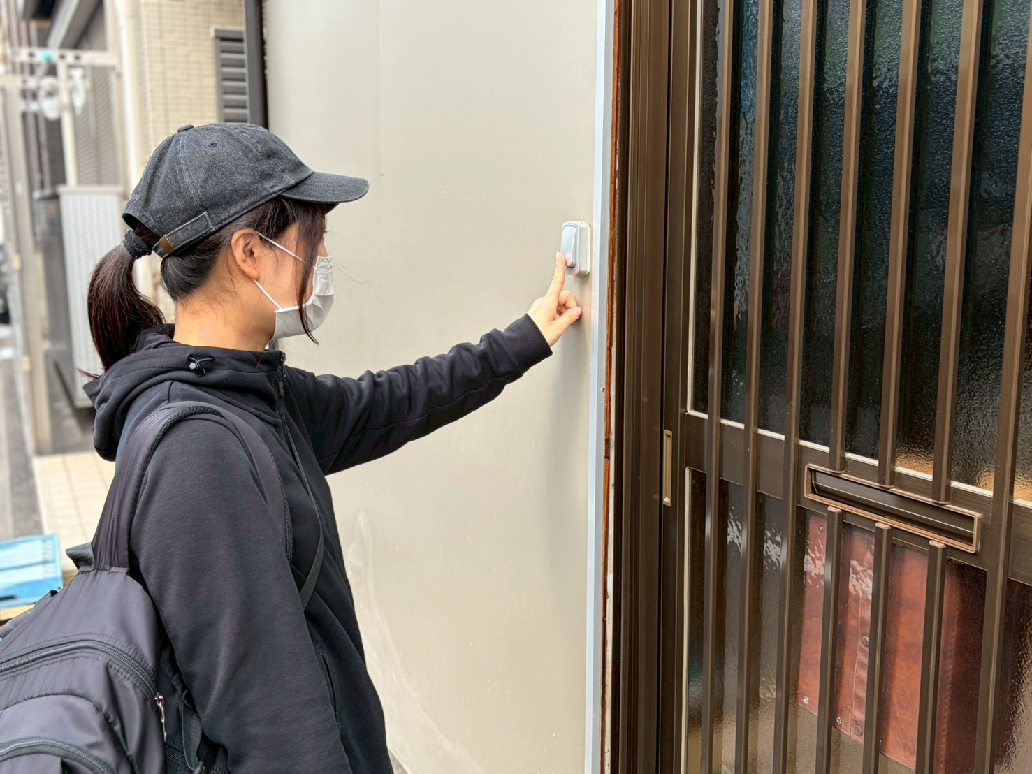 訪問先の玄関でインターホンを押す訪問看護師（訪問看護師の一日の流れ）