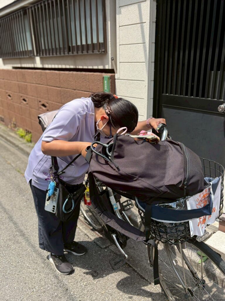 訪問看護師が自転車に積んだ訪問バッグを準備する様子